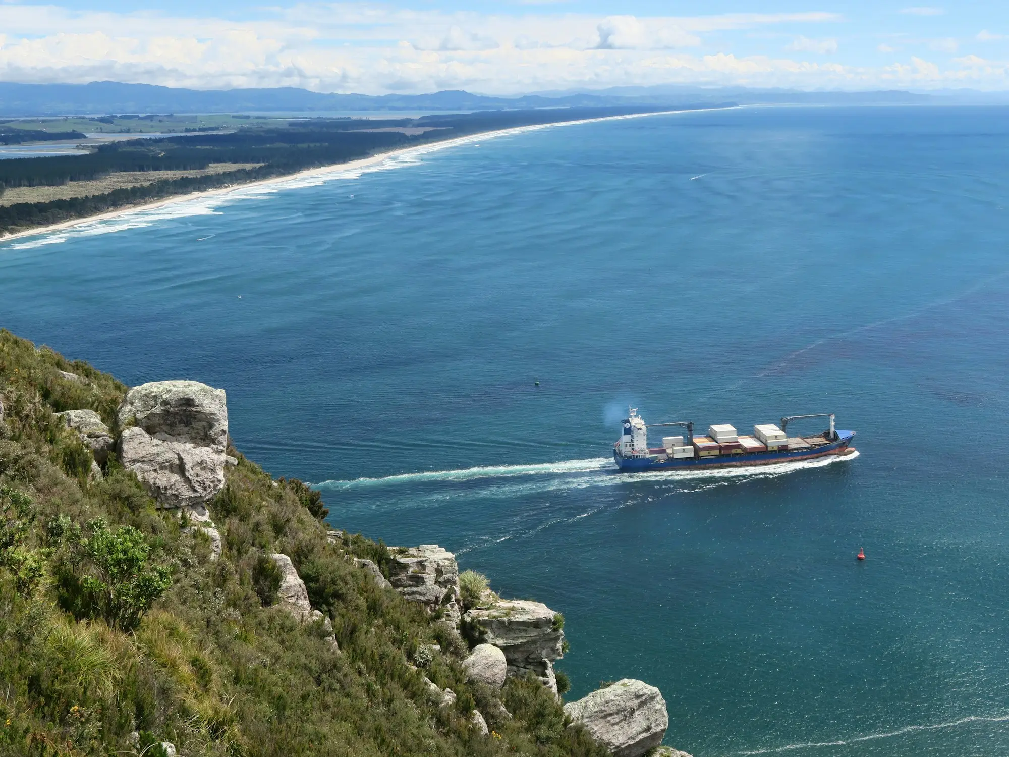 Container ship and cranes at the Port of Tauranga with Mount Maunganui behind